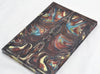 Close up of bookmatched Cosmic Dust resin knife scale handle material showing molten copper, gold, and turquoise diamond glitter.